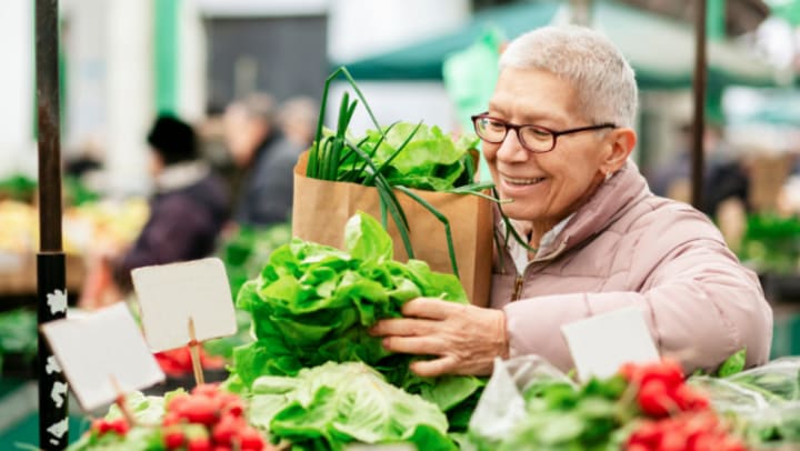 elderly woman looking vegetables