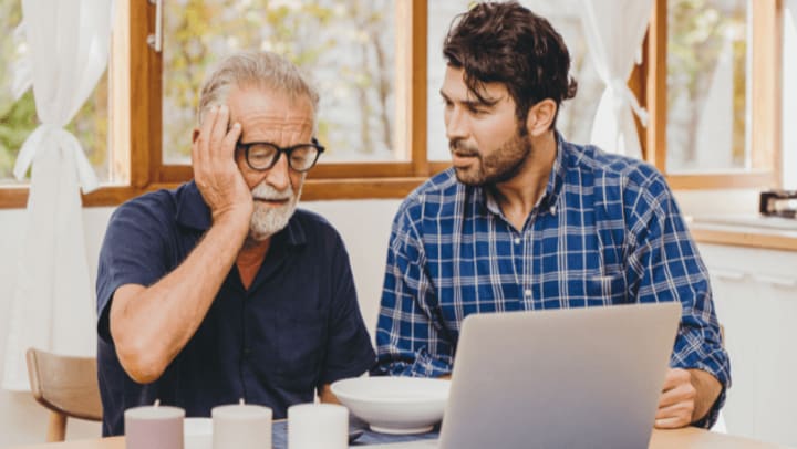 a son with his old dad that has a headache