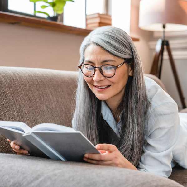 A resident reads a book on her sofa at Magnolia Run, Virginia Beach, Virginia