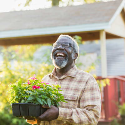 Ecstatic resident ready to plant some potted flowers at Cascade Park Gardens Memory Care in Tacoma, Washington