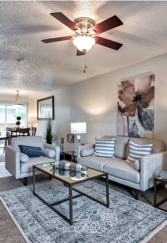 Resident living space with plush carpeting and a ceiling fan at Cobblestone at Essen in Baton Rouge, Louisiana