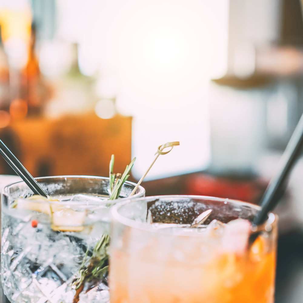 Assorted cocktails with garnishes and straws served at Titan Court in Eugene, Oregon