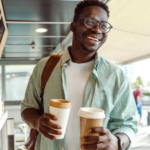 A man carrying coffee cups near Marea in Dana Point, California  