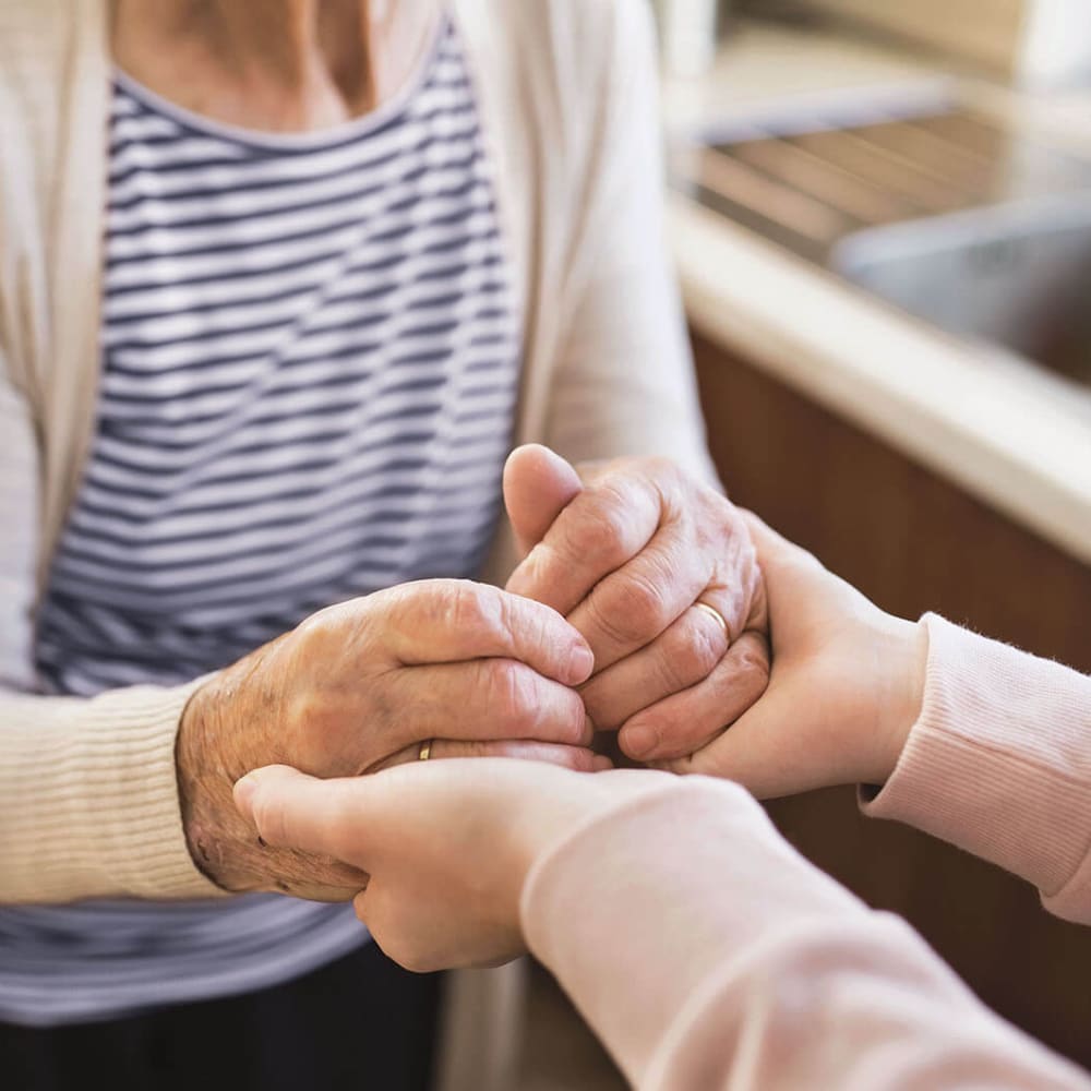 Resident holding hands with a caretaker at Anthology of Tanglewood in Houston, Texas