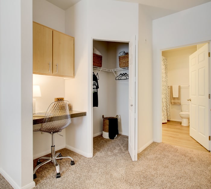 Study nook, walk-in closet, and en suite bathroom in the master bedroom of a model home at River Trail Apartments in Puyallup, Washington