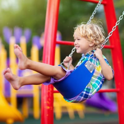 Kids swinging at a playground near Canterbury Courts in Richardson, Texas