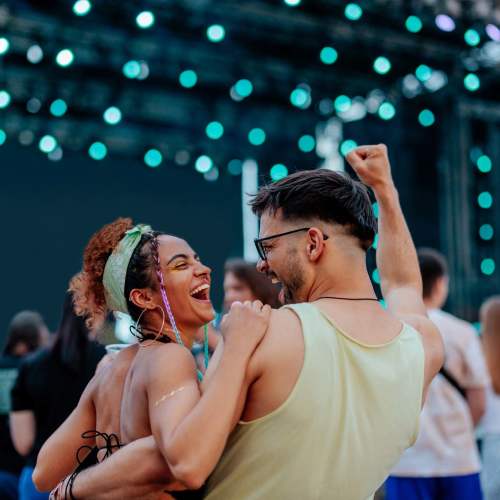 Couple dancing joyfully with colorful lights near Avia Lofts at Maple Road in Amherst, New York