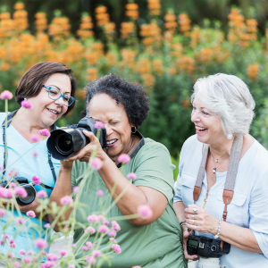 Resident taking a picture of some flowers with a large camera at The Spring at Silverton in Fort Worth, Texas