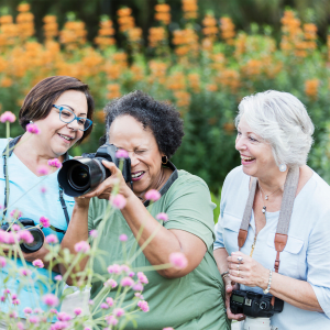 Resident taking a picture of some flowers with a large camera at King City Senior Village in King City, Oregon