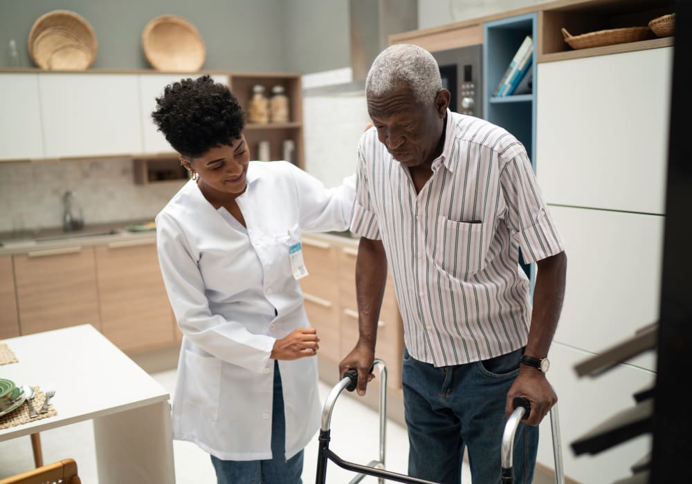 A staff member helping a patient walk in their home near Careage Home Health in Dupont, Washington. 