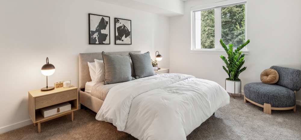 Bright bedrooms with window coverings at Traxx Apartments in Mountlake Terrace, Washington 