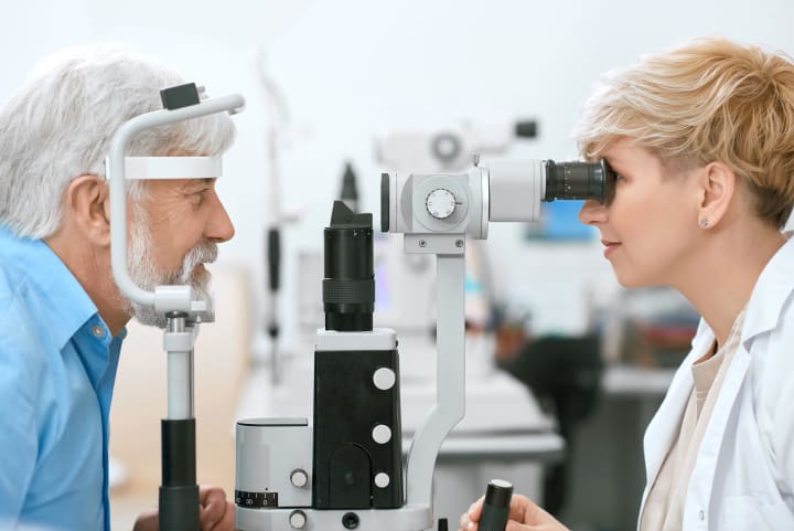 Aging male getting eye exam with optometrist