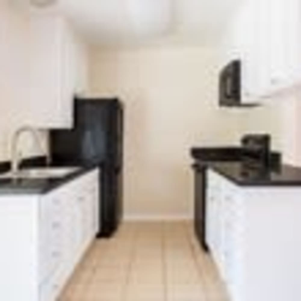 Kitchen with white cabinets and black countertops at our Redwood Manor community at Mission Rock at Sonoma in Sonoma, California