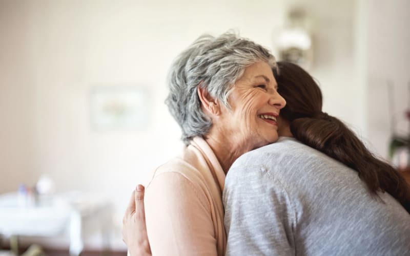 Resident hugging a caretaker at a MBK Senior Living community