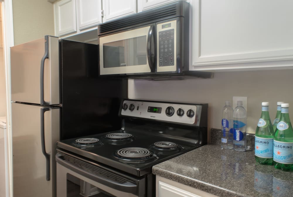 Kitchen with stainless steel appliance and white cabinets at Hayden at Enclave in Houston, Texas