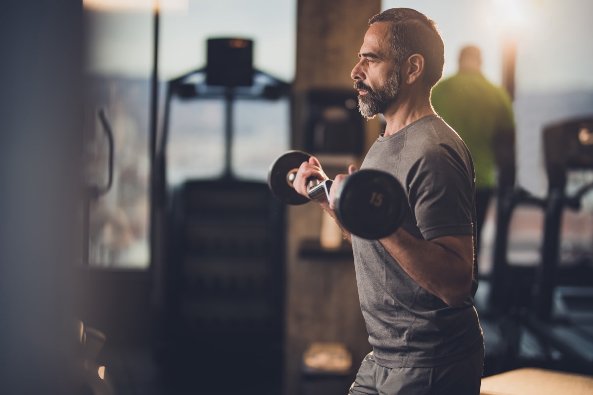 Man working out in the fitness center at The Pointe at Siena Ridge in Davenport, Florida