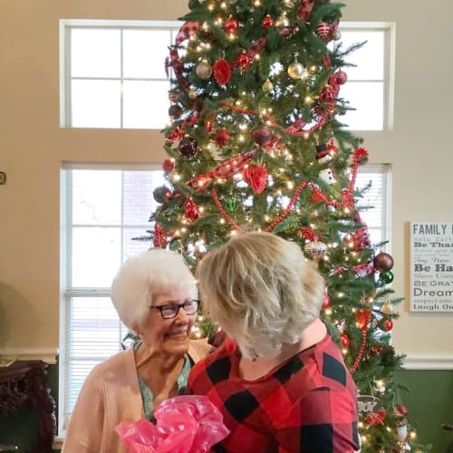 Masked caretaker with a resident at Canoe Brook Assisted Living in Duncan, Oklahoma
