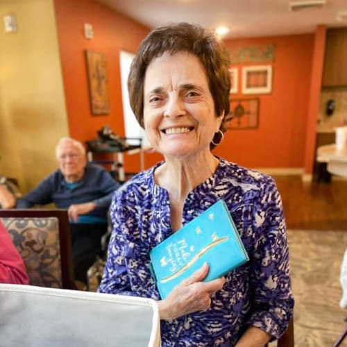 A happy resident sitting inside of The Oxford Grand Assisted Living & Memory Care in McKinney, Texas