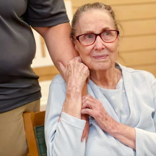 Resident holding caretaker at Oxford Glen Memory Care at Owasso in Owasso, Oklahoma