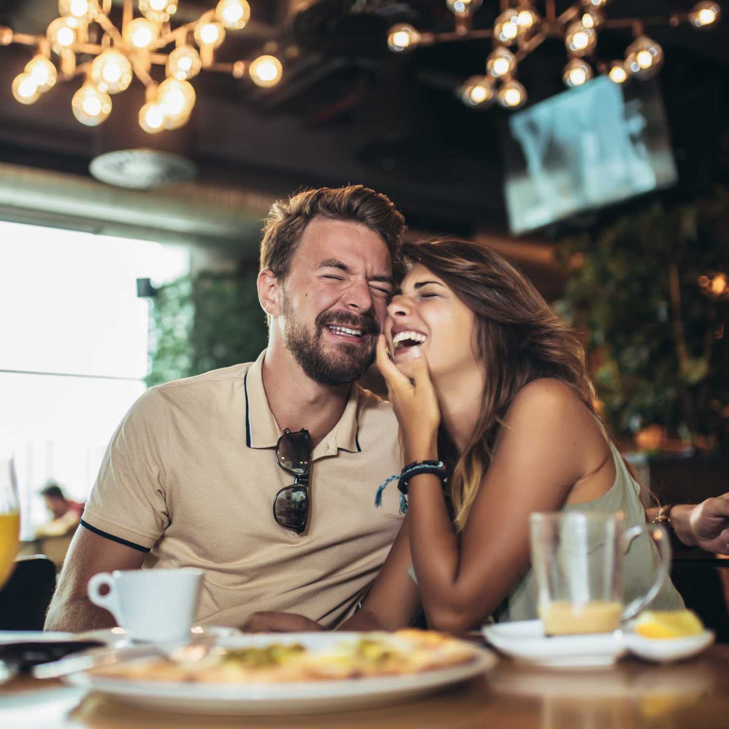 A couple enjoying a joyful moment together as they savor a meal at a cafe nearby Oxford Oaks Apartments, Edmond, Oklahoma