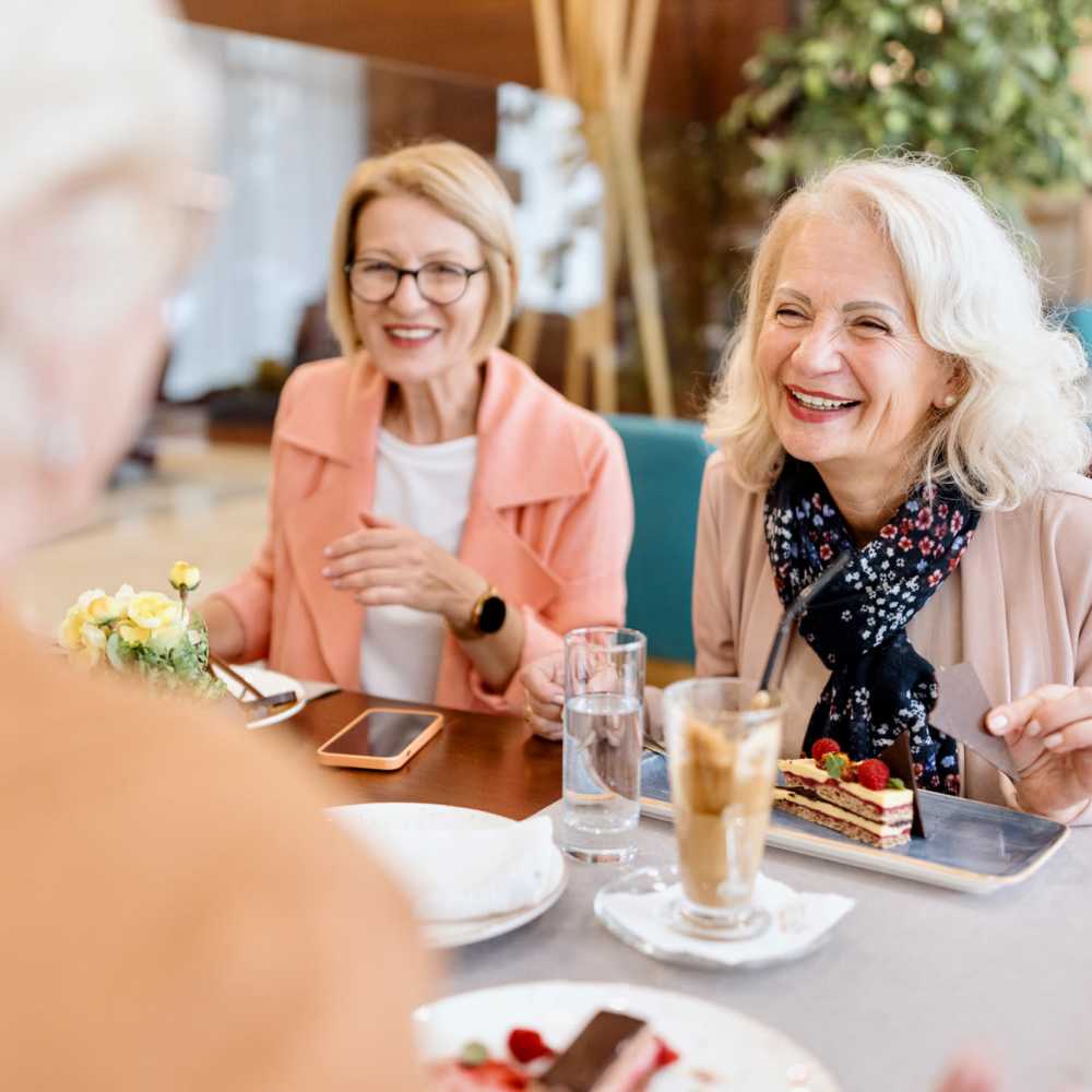 Resident friends sharing a laugh over a meal at their favorite restaurant near Acapella in Las Vegas, Nevada