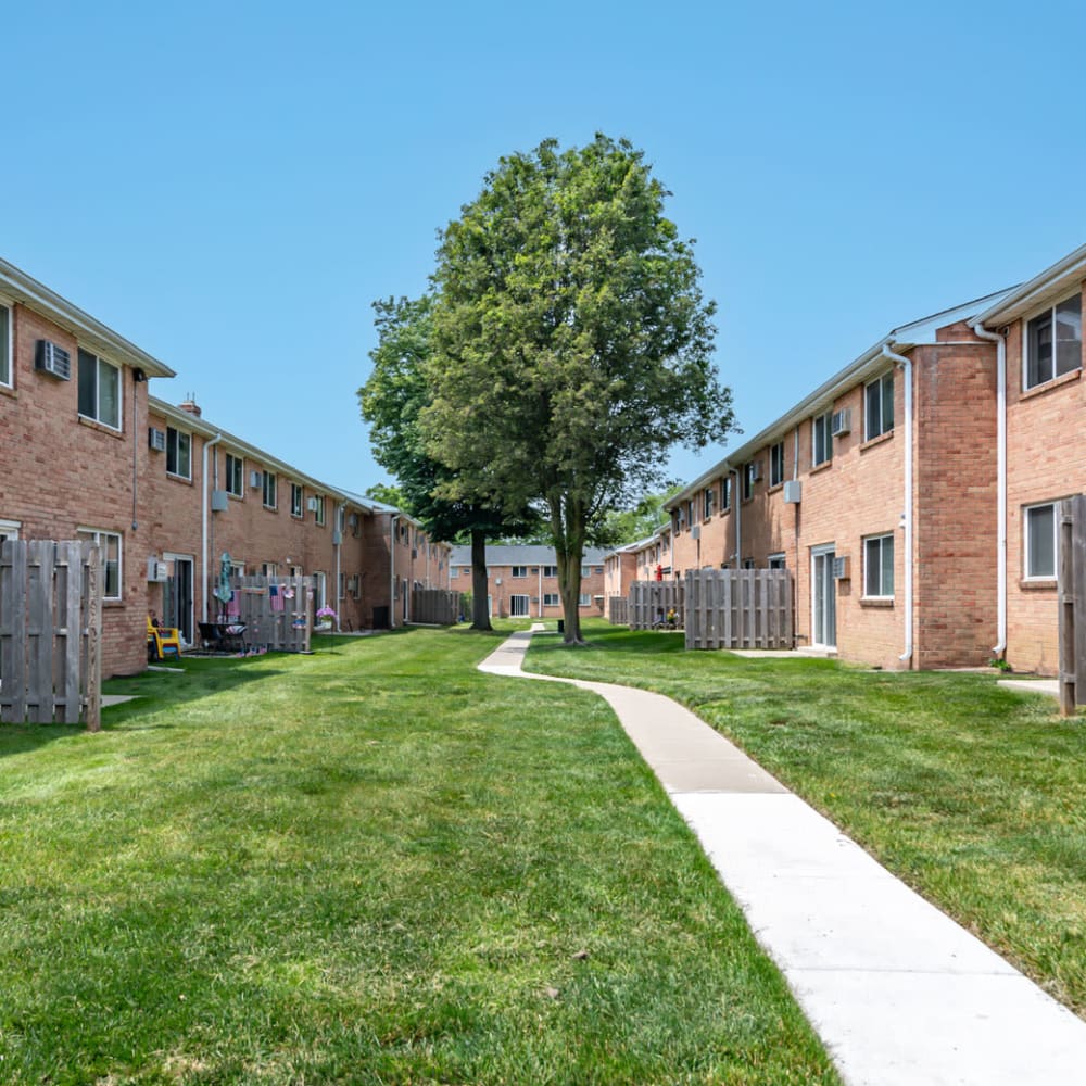 Apartment patios overlooking a grassy area with sidewalk at Warwick Terrace Apartment Homes in Somerdale, New Jersey