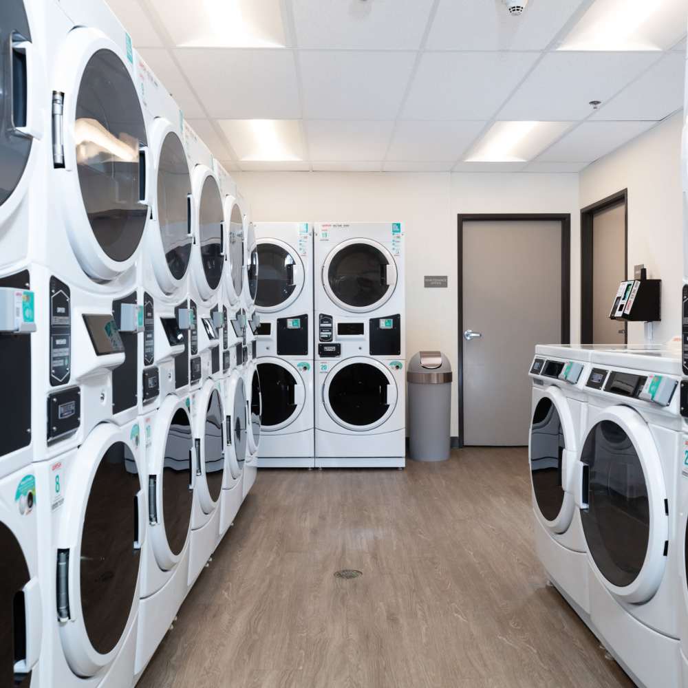 Clean, modern laundry center at Golden West Tower Apartments in Torrance, California