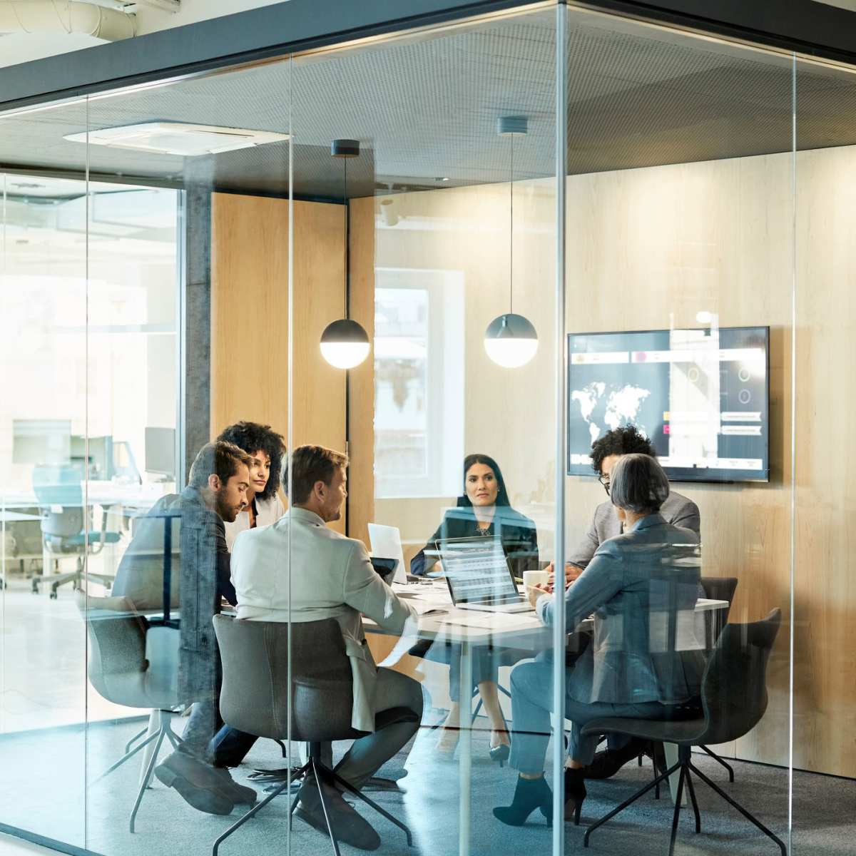 Team members having a meeting in a glass office at PK Companies in Okemos, Michigan