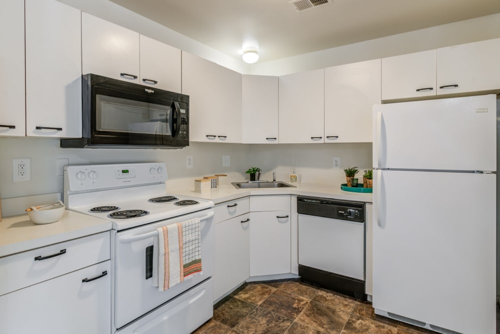 Kitchen with classic white cabinets and white appliances at Seagrass Cove Apartment Homes