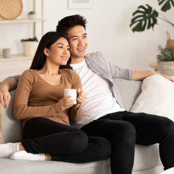 A couple sits on a sofa in their apartment at Rockwood Park, Richmond, Virginia