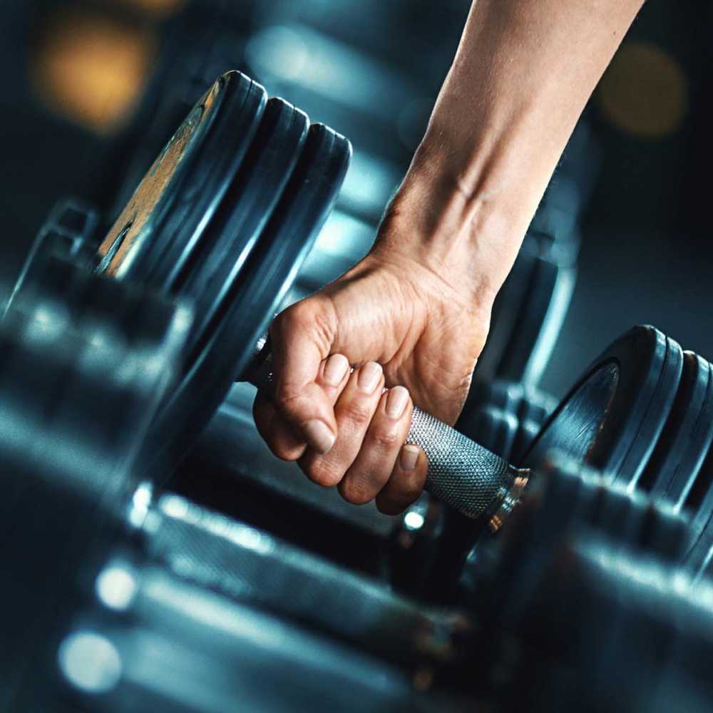 Strong hand gripping dumbbell in gym at Alton Park in Fort Worth, Texas