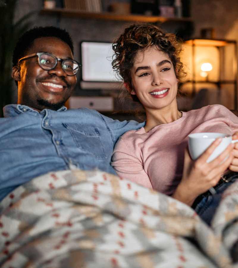 Couple enjoying their movie time together on the couch in their living room at Prosper 83 in Sparks, Nevada