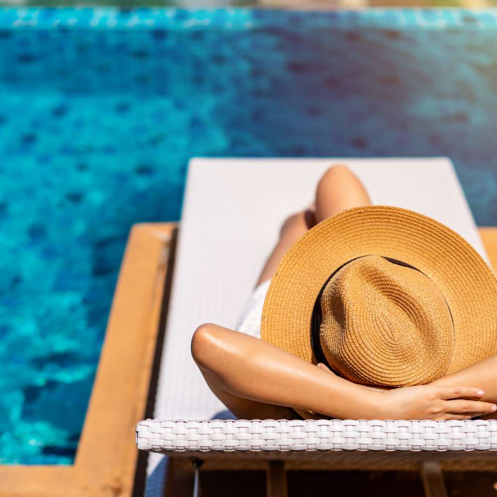 Resident woman relaxing on the edge of a pool at Malloy Bridge in Seagoville, Texas