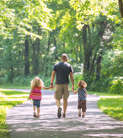 Resident father walking in the park along with his kids near Adagio at Westshore Palms in Tampa, Florida