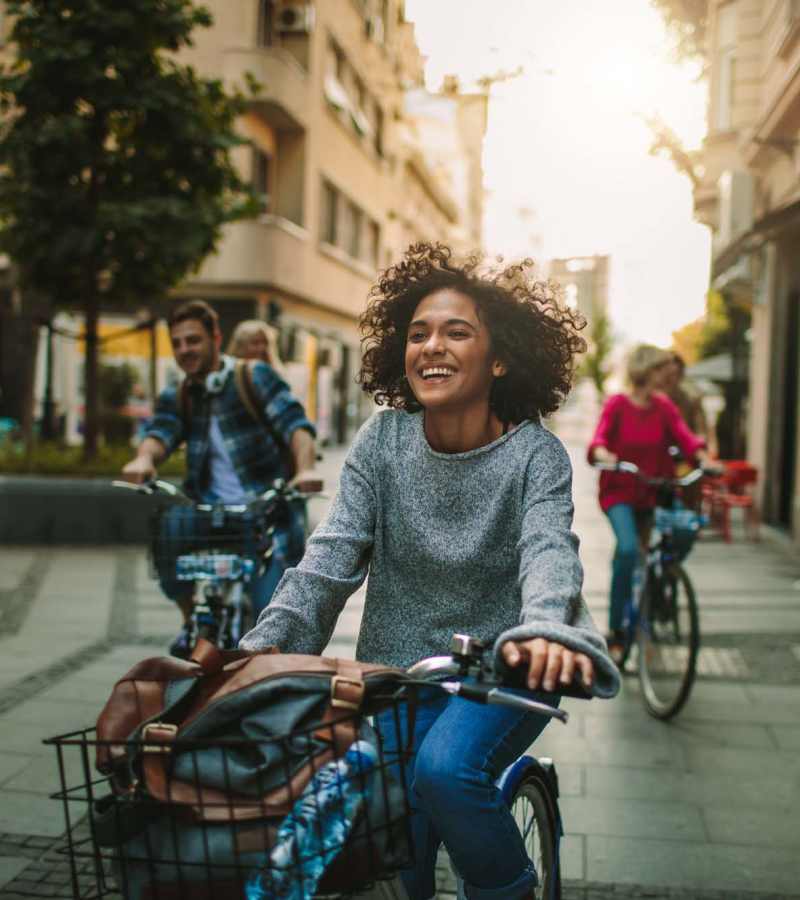 Group of friends biking together, smiling, enjoying an active, outdoor lifestyle at Dohr Apartments in Rochester, New York