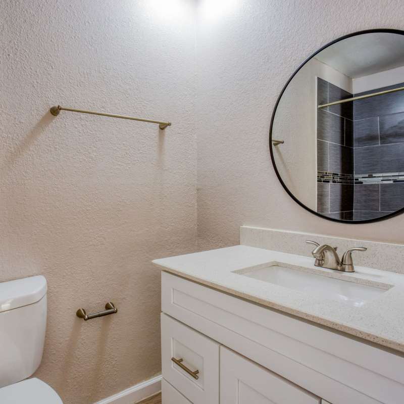 Bathroom with mirror and storage space at The Summit Apartments in Athens, Texas