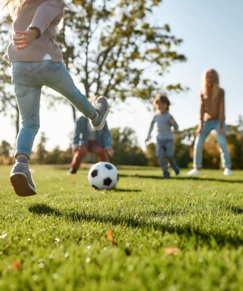 Family playing soccer in a park near The Shockoe Collection in Richmond, Virginia