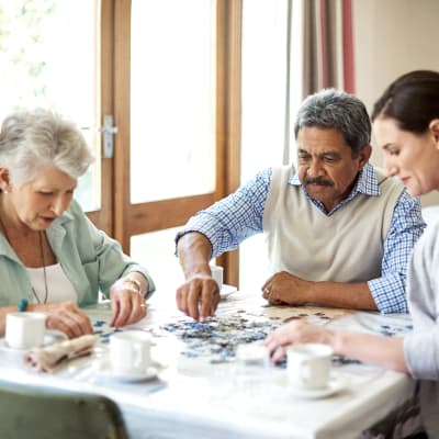 A family putting a puzzle together at Arbor Rose Senior Care in Mesa, Arizona