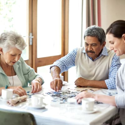 A family putting a puzzle together at Sierra Ridge Memory Care in Auburn, California