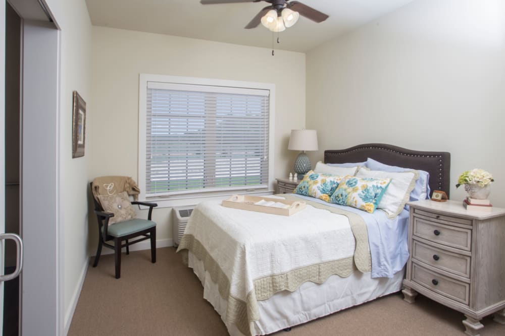 Resident bedroom with windows at The Claiborne at McComb in McComb, Mississippi. 