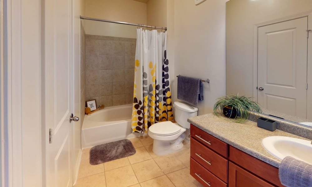 Bathroom with a granite countertop in a model home at The Hawthorne in Jacksonville, Florida