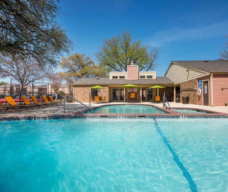 Large swimming pool with a sundeck at The Fairway Apartments in Plano, Texas