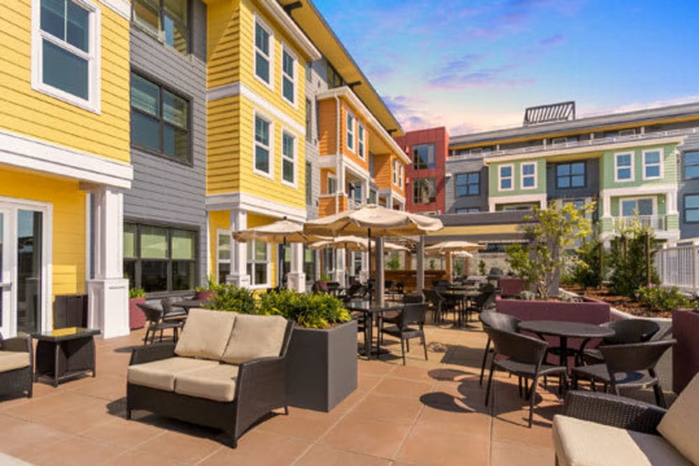 Sunny patio and colorful exterior of Merrill Gardens at Rockridge in Oakland, California