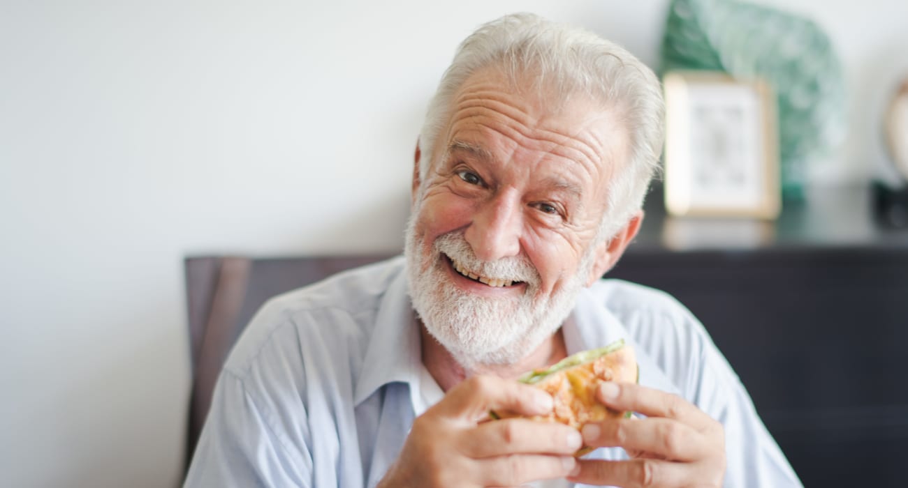Resident enjoying a burger at Truewood by Merrill, Bountiful in Bountiful, Utah.