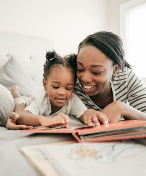 Family reading on the bed at Park Vista Apartments in San Antonio, Texas