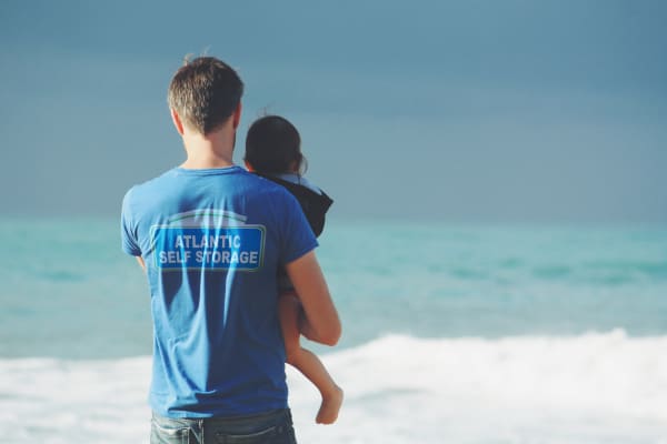 Adult holding a child near the beach