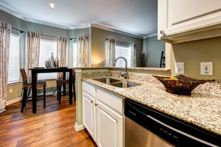 Renovated kitchen with granite countertops and hardwood flooring in a model home at Baypoint in Corpus Christi, Texas