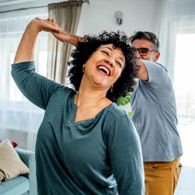 Couple dancing joyfully in living room at Valley Brook Townhomes in Rochester, New York