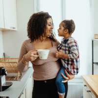 Woman holding toddler in modern kitchen at The Reid in Tucker, Georgia