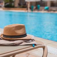 Outdoor swimming pool with cahirs at Timber View Apartments in Grand Haven, Michigan
